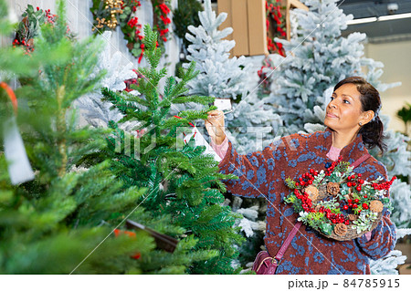 Woman chooses christmas tree at shop 84785915