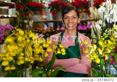 Woman seller posing with orchids in pots Woman seller posing with orchids in pots 84786072