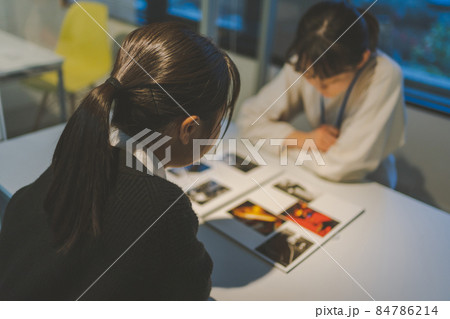 自分のブックを見せるカメラマン志望の女子高校生 84786214