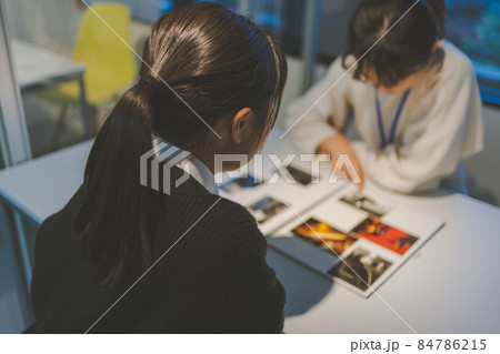 自分のブックを見せるカメラマン志望の女子高校生 84786215