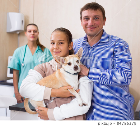 Father and daughter visiting veterinarian clinic with their puppy 84786379