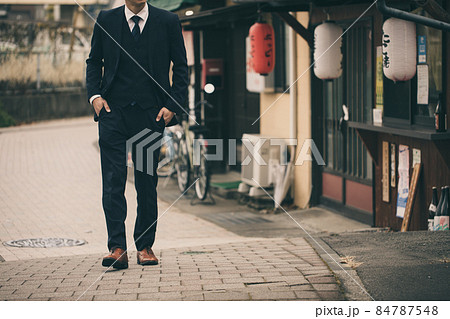 飲み屋街をスーツで歩く男性　Men 84787548