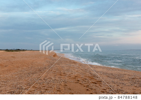 Cloudy sky on the light by the sea, fishermen with fishing rods, landscape. Russia, sea of Azov, summer. 84788148