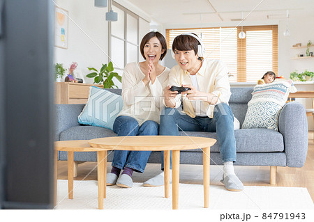 子供をほったらかしてオンラインゲームに熱狂する若いカップル 84791943