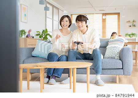 子供をほったらかしてオンラインゲームに熱狂する若いカップル 84791944