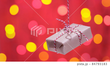 The decorative gift box tied with a red ribbon rotates on a rope 84793183