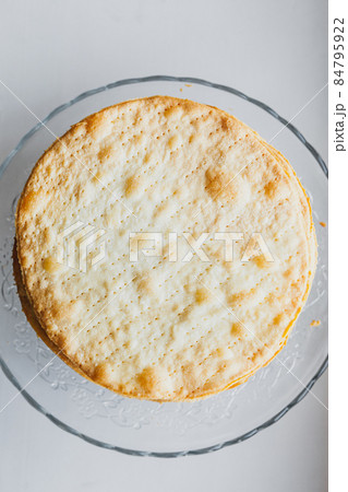 Baked crumpets cakes made of puff pastry for layer cake on a glass stand on windowsill. Semi-finished product for cake. Close up top view Baked crumpets cakes made of puff pastry for layer cake on a glass stand on windowsill. Semi-finished product for cake. Close up top view 84795922