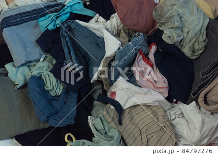 Top view of a pile of clothes. Various colors and textures. Overconsumption and clutter concept Top view of a pile of clothes. Various colors and textures. Overconsumption and clutter concept 84797276