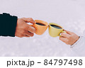 Two cups of coffee in the hands of happy couple. Winter theme 84797498