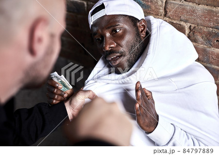 Side View On Caucasian Bandit Hooligan Demanding Money From African Stranger 84797889