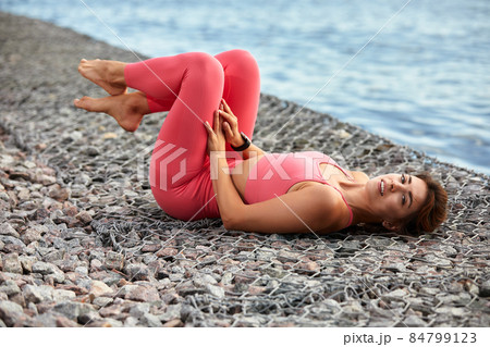Attractive athletic woman exercising outdoors in the morning. Young beautiful woman with a slim figure goes in for sports at beach. Fitness, sport and healthy lifestyle concept. Attractive athletic woman exercising outdoors in the morning. Young beautiful woman with a slim figure goes in for sports at beach. Fitness, sport and healthy lifestyle concept. 84799123