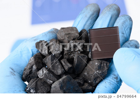Handful of coal in one hand and solar panel in other. Handful of coal in one hand and solar panel in other. 84799664