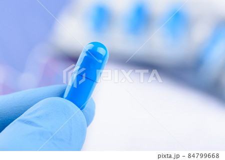 Scientist hold in hand blue pill capsule. Scientist hold in hand blue pill capsule. 84799668