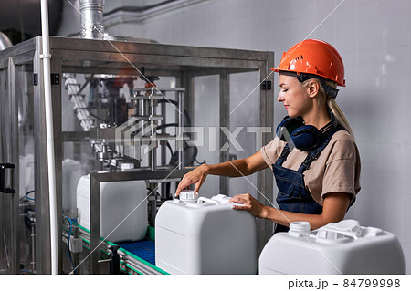 female in hardhat closes the lid of canister container with pesticides, preparing female in hardhat closes the lid of canister container with pesticides, preparing 84799998