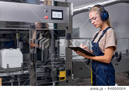 confident woman rate the quality of pesticides production in factory, take notes confident woman rate the quality of pesticides production in factory, take notes 84800004