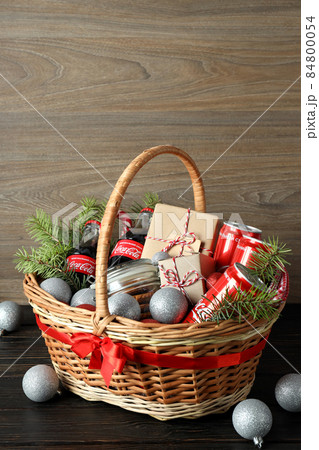 Odessa, Ukraine - November 10, 2021: Concept of gift with Christmas basket on dark table Odessa, Ukraine - November 10, 2021: Concept of gift with Christmas basket on dark table 84800054