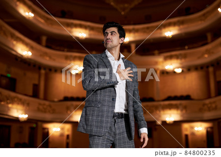talented actor performing a monologue in theater to audience, talented brunette guy portrait 84800235