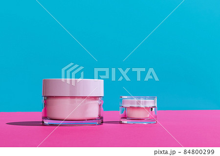 Jars of facial cosmetic cream with copy space for your brand isolated on bright colored background. Mockup 84800299