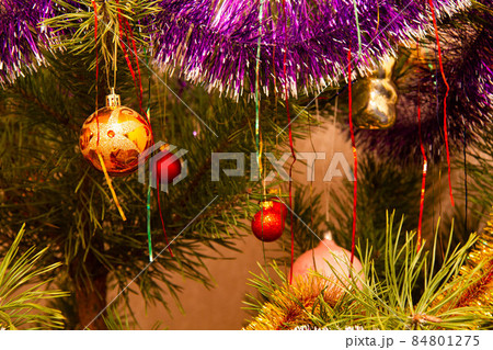 The Christmas tree is decorated with glass Christmas toys. Beautiful New Year decorations on the New Year tree. Colorful Christmas decorations. Colored bright glass balls. Holiday wallpaper 84801275