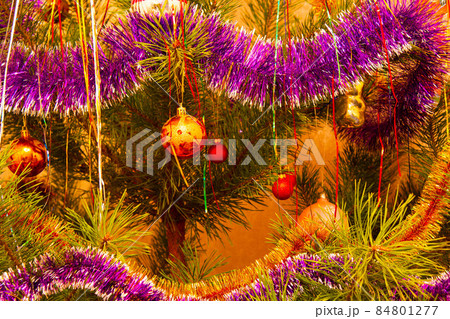 The Christmas tree is decorated with glass Christmas toys. Beautiful New Year decorations on the New Year tree. Colorful Christmas decorations. Colored bright glass balls. Holiday wallpaper 84801277