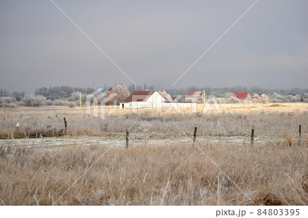 Winter. The sunbeam illuminates the house. Winter. The sunbeam illuminates the house. 84803395