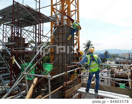 MALACCA, MALAYSIA -MARCH 25, 2016: Construction workers fabricating column timber form work and reinforcement bar at the construction site in Malacca, Malaysia.  84803578
