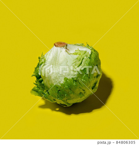 Iceberg lettuce salad on a solid yellow background Iceberg lettuce salad on a solid yellow background 84806305