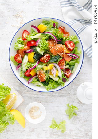 Salted salmon salad with fresh green lettuce, cucumbers, tomato, bell pepper and red onion. Ketogenic, keto or paleo diet lunch bowl. Top view Salted salmon salad with fresh green lettuce, cucumbers, tomato, bell pepper and red onion. Ketogenic, keto or paleo diet lunch bowl. Top view 84806654
