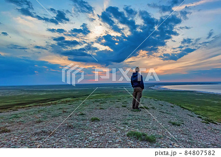 Back view young male hiker looks at sea and horizon 84807582