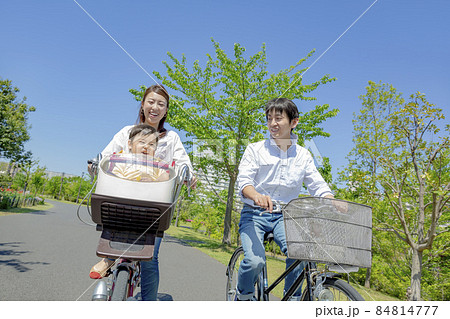 新緑の公園で自転車に乗る3人家族 84814777