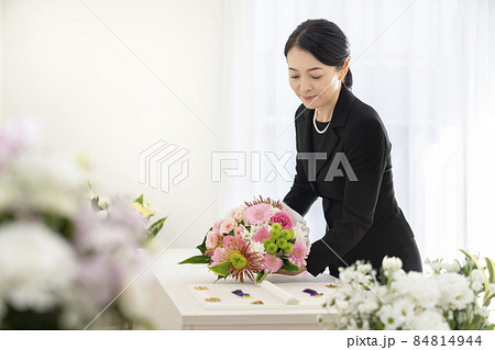棺に花束を供えるミドルの女性 棺に花束を供えるミドルの女性 84814944
