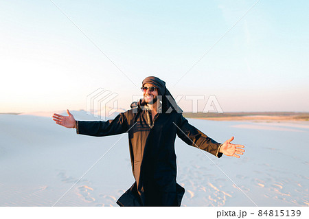 Happy fellow Arabian, walks through desert, smiles and enjoys life on summer evening. Happy fellow Arabian, walks through desert, smiles and enjoys life on summer evening. 84815139