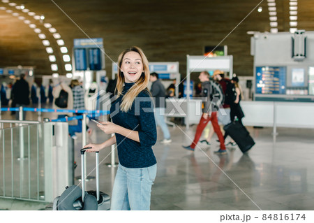 Caucasian female person chatting by smarphone at airport hall. 84816174