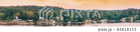 Sweden. Many Beautiful Swedish Wooden Log Cabins Houses On Rocky Island Coast In Summer Evening. Lake Or River Landscape. Panorama, Panoramic View. Sweden. Many Beautiful Swedish Wooden Log Cabins Houses On Rocky Island Coast In Summer Evening. Lake Or River Landscape. Panorama, Panoramic View. 84818153