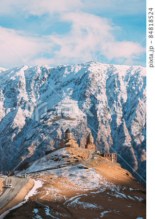 Stepantsminda, Georgia. Famous Gergeti Trinity Tsminda Sameba Church In Early Winter Landscape. Beautiful Georgian Mountains Landscape 84818524