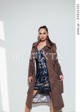 beautiful woman in a warm brown coat on a white background beautiful woman in a warm brown coat on a white background 84820182