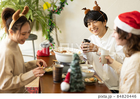 部屋でクリスマス会をする若い男女 部屋でクリスマス会をする若い男女 84820446