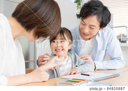 ママに上前歯の抜けた口を見せる小学生の女の子とパパ ママに上前歯の抜けた口を見せる小学生の女の子とパパ 84820987