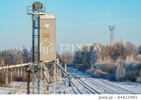 Metal grain elevator next to railroad during winter season 84823965