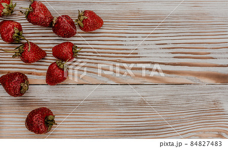 Juicy red strawberry lies on the wooden board 84827483