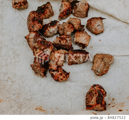 Pork veal cow meat fried lies on a thin white pita bread. Pork veal cow meat fried lies on a thin white pita bread. 84827522