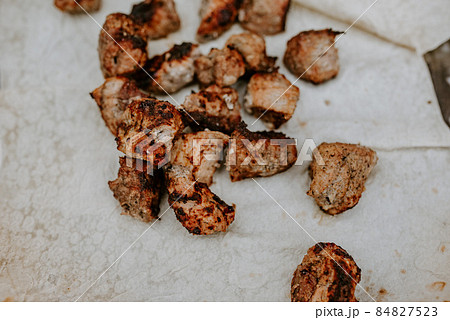 Pork veal cow meat fried lies on a thin white pita bread. Pork veal cow meat fried lies on a thin white pita bread. 84827523