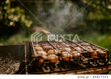mushrooms champignons stacked in a barbecue on the grill 84827543