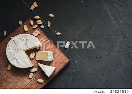 cheese camembert with mold and nuts on wooden board 84827659