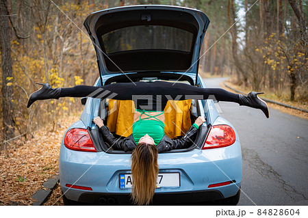 Sexy, flexible woman on the heels with car on the road doing stretching . Concept of yoga and healthy lifestyle  84828604