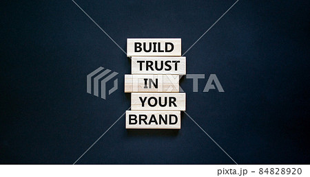 Success business process symbol. Wood blocks stacking as step stair on black background, copy space. Words 'build trust in your brand'. Business and trust brand concept. 84828920