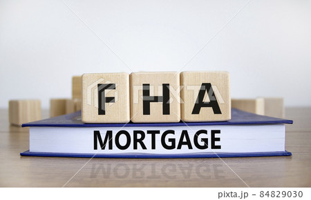FHA mortgage symbol. Wooden blocks and book with words 'FHA mortgage'. Beautiful white background, copy space. Business and FHA - federal housing administration mortgage concept. FHA mortgage symbol. Wooden blocks and book with words 'FHA mortgage'. Beautiful white background, copy space. Business and FHA - federal housing administration mortgage concept. 84829030