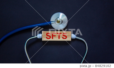 COVID-19 Pandemic Coronavirus and medical concept. Wooden block with the inscription 'SFTS' and stethoscope. Beautiful black background. COVID-19 Pandemic Coronavirus and medical concept. Wooden block with the inscription 'SFTS' and stethoscope. Beautiful black background. 84829102