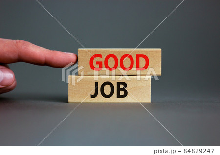 Good job symbol. Concept words 'good job' on wooden blocks on a beautiful grey background. Businessman hand. Business and good job concept, copy space. 84829247