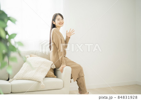 ソファのヘリに座る女性（同棲） 84831928
